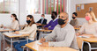 © JackF - Group of adult students in protective masks at lecture at the university