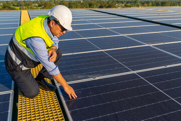 Wall Mural - asian man engineer using digital tablet maintaining solar cell panels on building rooftop. technicia