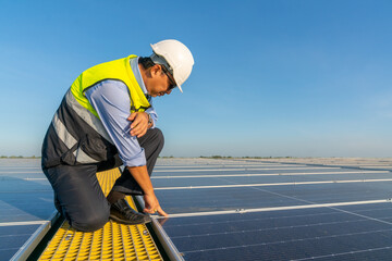 Wall Mural - asian man engineer using digital tablet maintaining solar cell panels on building rooftop. technicia