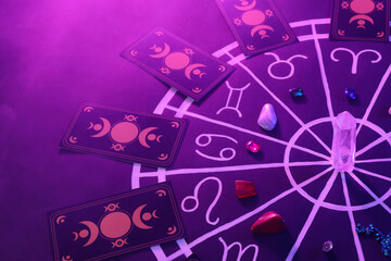 natural stones for zodiac signs, tarot cards and drawn astrology chart on purple background. color t