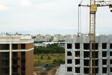 Construction site with tower crane near unfinished building