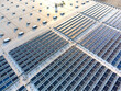 © MVProductions - Large solar panel array farm on a commercial warehouse building in sunset aerial view
