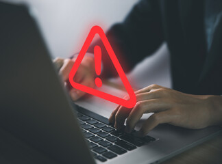 Wall Mural - businessman using laptop showing warning triangle and exclamation sign icon warning of dangerous pro