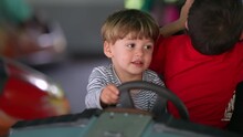 Child having fun at bumper car at the fun fair. little boy driving dodgem cars. Childhood entertainment at amusement park