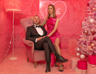 The couple of lovers on the pink fur background closeup with festive decorations 