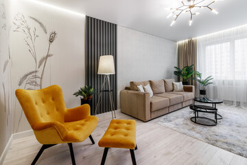 Modern interior design of a living room with a mustard chair, a floor lamp and personal accessories.