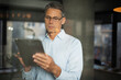 © JustLife - Portrait of businessman in office. Man using digital tablet. Businessman having video call