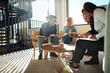 © Flamingo Images - Diverse businesspeople laughing while discussing paperwork during a meeting