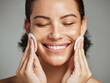 © K.A./peopleimages.com - Skincare, cotton swab and face of woman on gray background for dermatology, wellness and healthy skin. Spa aesthetic, beauty and happy girl with pad for makeup removal, facial treatment and cosmetics