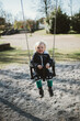 © Anna Malgina/Stocksy - A toddler on a swing