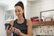© Sean Locke/Stocksy - Home: Woman Uses Smart Phone Before Home Workout