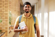 © K.A./peopleimages.com - Face portrait, student and man in university ready for back to school learning, goals or targets. Scholarship, education and happy, confident and proud male from India holding tablet for studying.