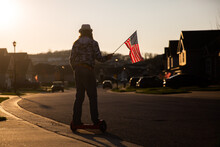 Boy Riding A Hover Board While Holding American Flag