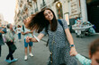 © Jimena Roquero/Stocksy - Woman and kid playing in crowded old italian city street smiling