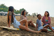 © Jovo Jovanovic/Stocksy - Female friends talking while relaxing during beach holiday
