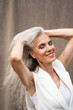 © Alba Vitta/Stocksy - Portrait of mature woman touching hair