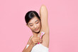 © Marc Tran/Stocksy - a young girl cares for her body, shaves her armpits with a pink razor