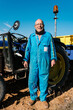 © Ezequiel Giménez/Stocksy - Content farmer near tractor in sunlight