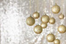 Golden Christmas Baubles Against Shiny Background