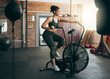 © K.A./peopleimages.com - Fitness, exercise bike and woman at gym for workout, cardio training and cycling for energy, balance and lose weight. Sports female or athlete with spinning machine for health, wellness and self care