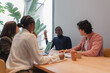 © Milles Studio/Stocksy - Black manager speaking with coworkers