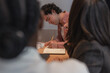 © Milles Studio/Stocksy - Man making notes near colleagues