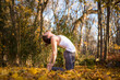 © Cavan Images - Young woman in yoga pose amidst fallen autumn leaves, North Kingstown, Rhode Island, USA
