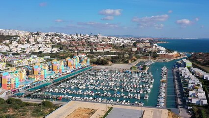 Wall Mural - Delightful aerial view of sea bay of marina for ships and yachts with a perspective on picturesque tourist town of Albufeira. Portugal, Algarve. with sea views.