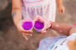 © Ezequiel Giménez/Stocksy - Crop children showing cups with purple color powders