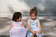 © Ezequiel Giménez/Stocksy - Cute girls sitting on street