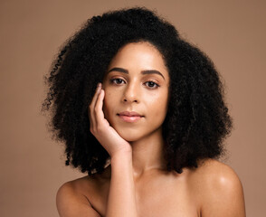 Beauty, black woman and hair care portrait for luxury hair cosmetics or skincare wellness in brown background studio. Young African model, healthy and natural waves hairstyle or dermatology treatment