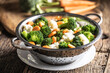 Leinwandbild Motiv Steamed broccoli, carrots and cauliflower in a stainless steel steamer. Healthy vegetable concept