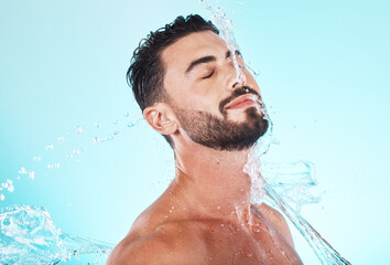 Water, splash and skincare with face of man for shower, self care and natural cosmetics. Luxury, hydration and refreshing with model for dermatology, wellness and cleaning in blue background studio