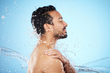 Canvas Print - Man, water splash and clean for skincare, wellness and health with beauty, grooming and on blue studio background. Cleaning, male and shower for washing, organic care and hygiene for natural skin.