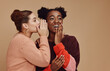 Friends, gossip and black woman laughing at secret on studio background and product placement mockup. Secrets, rumor and surprise whisper in ear, happy women smile discuss discount sale announcement