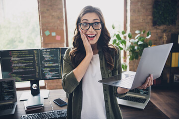 Photo of astonished positive lady hardware engineer hand cheeks impressed proposition high salary good job web site indoor room workstation