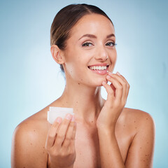 Wall Mural - Portrait, beauty and product with a model woman holding a container in studio on a blue background to promote skincare. Face, wellness or luxury and an attractive female with cream to apply on skin