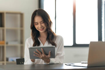 Wall Mural - Beautiful woman Asian using digital tablet work at the office.