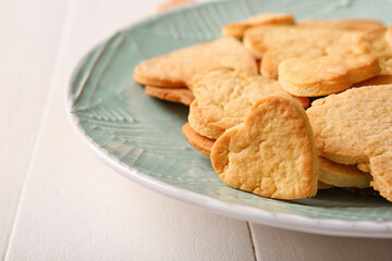 Wall Mural - Plate with tasty heart shaped cookies on light wooden background, closeup. Valentines Day celebration