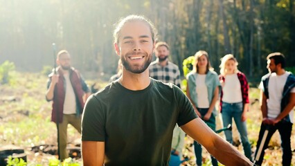 portrait of caucasian young handsome man eco volunteer smiling to camera with shovel in hands while 