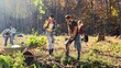 © ihorvsn - Caucasian people coworking together in park as eco activists and planting seedlings of trees on sunny autumn day. Outside. Environmental activism. Volunteers protecting green planet.