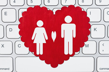 Canvas Print - Red wood heart with a man and woman on a computer keyboard