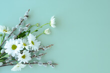 Spring Bouquet Of Flowers Of White Chamomile Or Daisies And Pussy Willow Twigs On A Green Background. Floral Background For Easter Holiday, Women's Day, 8 March