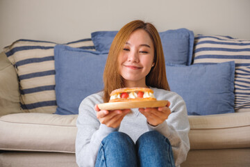 Wall Mural - Portrait image of a woman holding a plate of strawberry Eclair