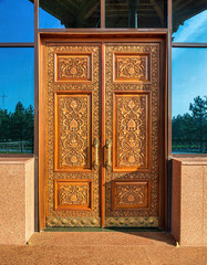 Wall Mural - Carved wooden doors with gilded metal handles..