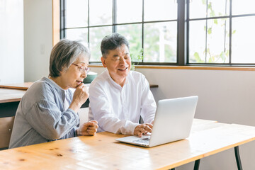 Sticker - 家のダイニングでパソコンを使う高齢者夫婦
