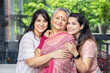 Portrait of two happy young indian daughters hug mother at home, Love and bonding, Asian family.