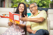 © GAJENDRRA BHATI  - Happy senior indian couple reading book or novel together at home. 60s Retired husband wife spend time with each other and having fun. Retirement life.