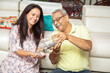 © GAJENDRRA BHATI  - Happy mature senior Indian couple pouring coins money from jar while sitting at home. Savings and banking concept