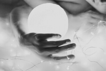 Wall Mural - Close up woman with glowing neon ball monochrome concept photo. Side view photography with fairy lights on background. High quality picture for wallpaper, travel blog, magazine, article